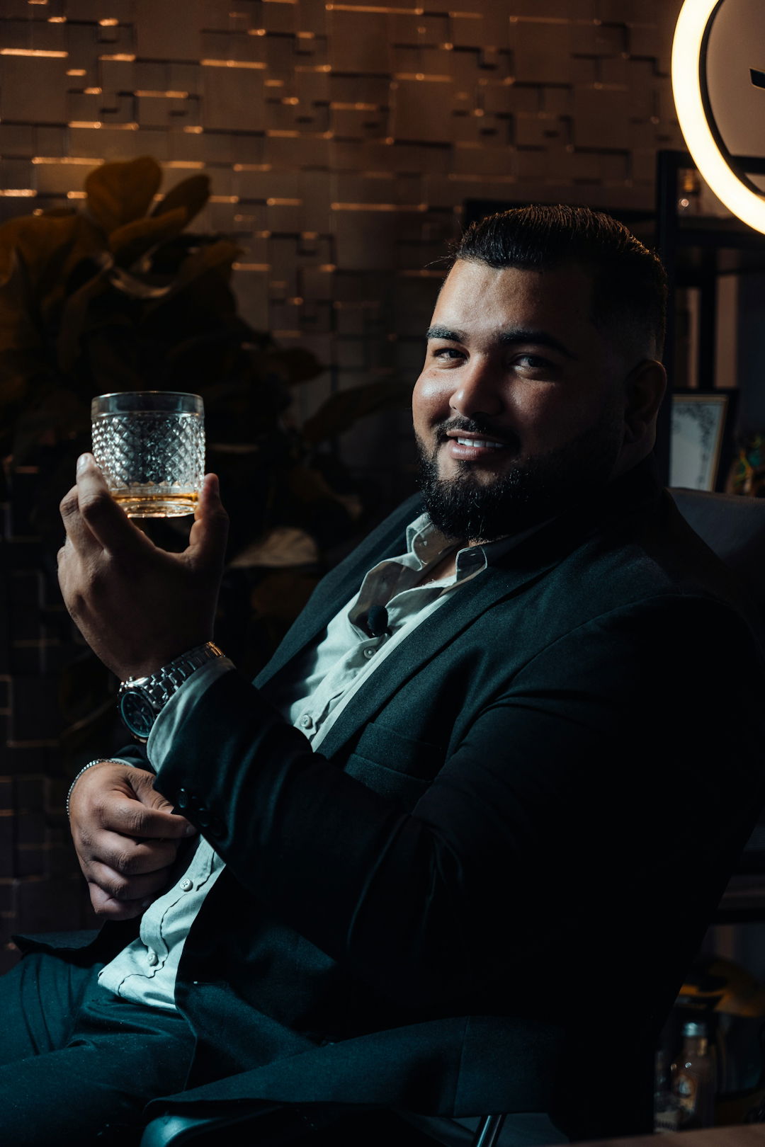 a man sitting in a chair holding a glass of wine